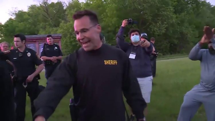 Michigan sheriff takes off helmet and drops baton  Marches with protestors